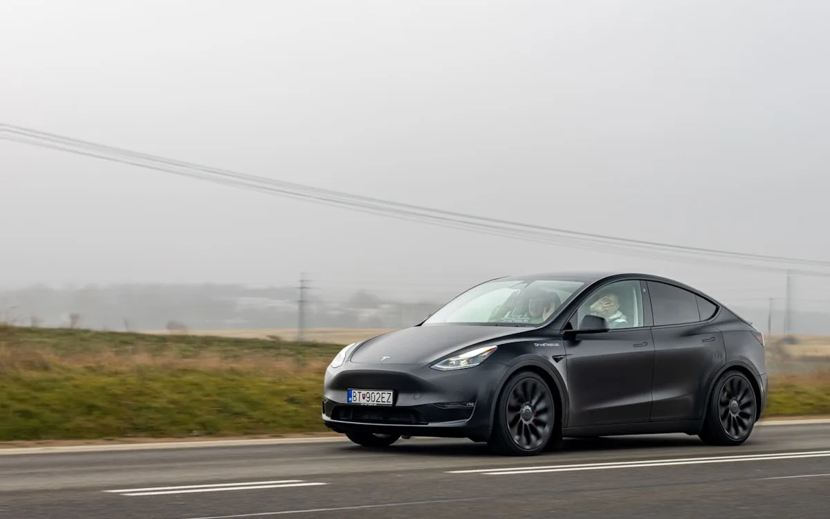 Coche Tesla negro conduciendo por la carretera — foto Unsplash