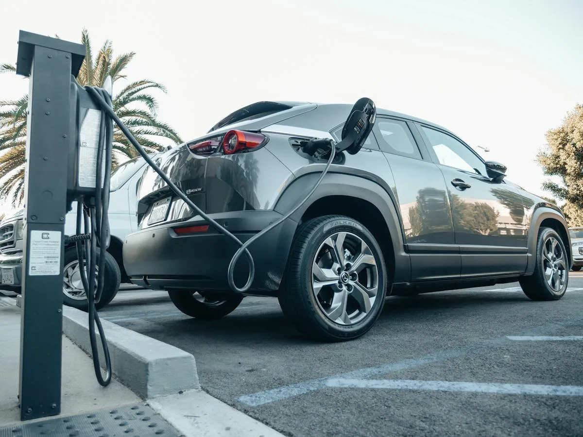 Coche eléctrico gris aparcado en una bahía de carga rápida